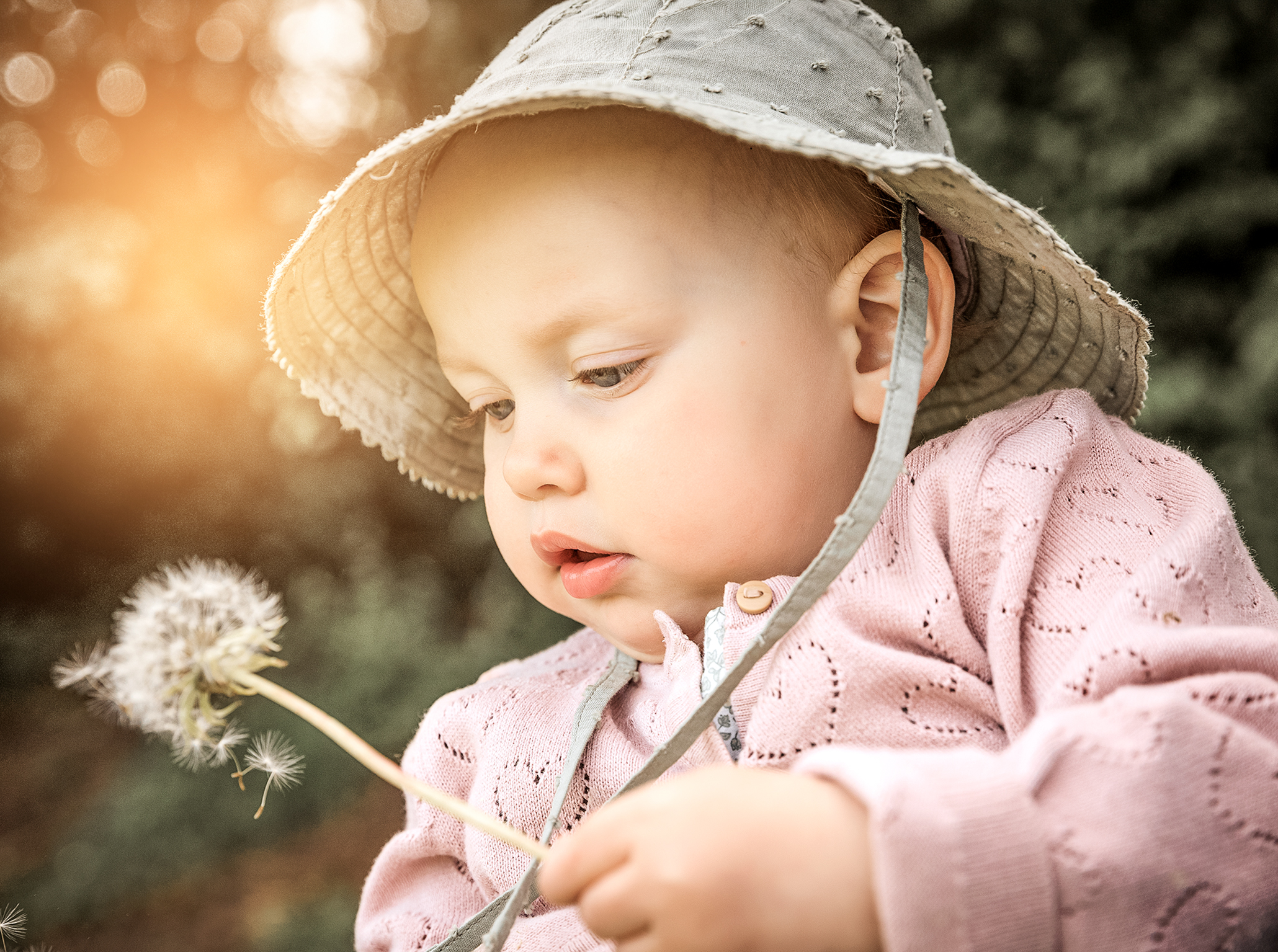 Close up Baby Portrait mit Pusteblume in der Hand, zarte und ruhige Aufnahme.