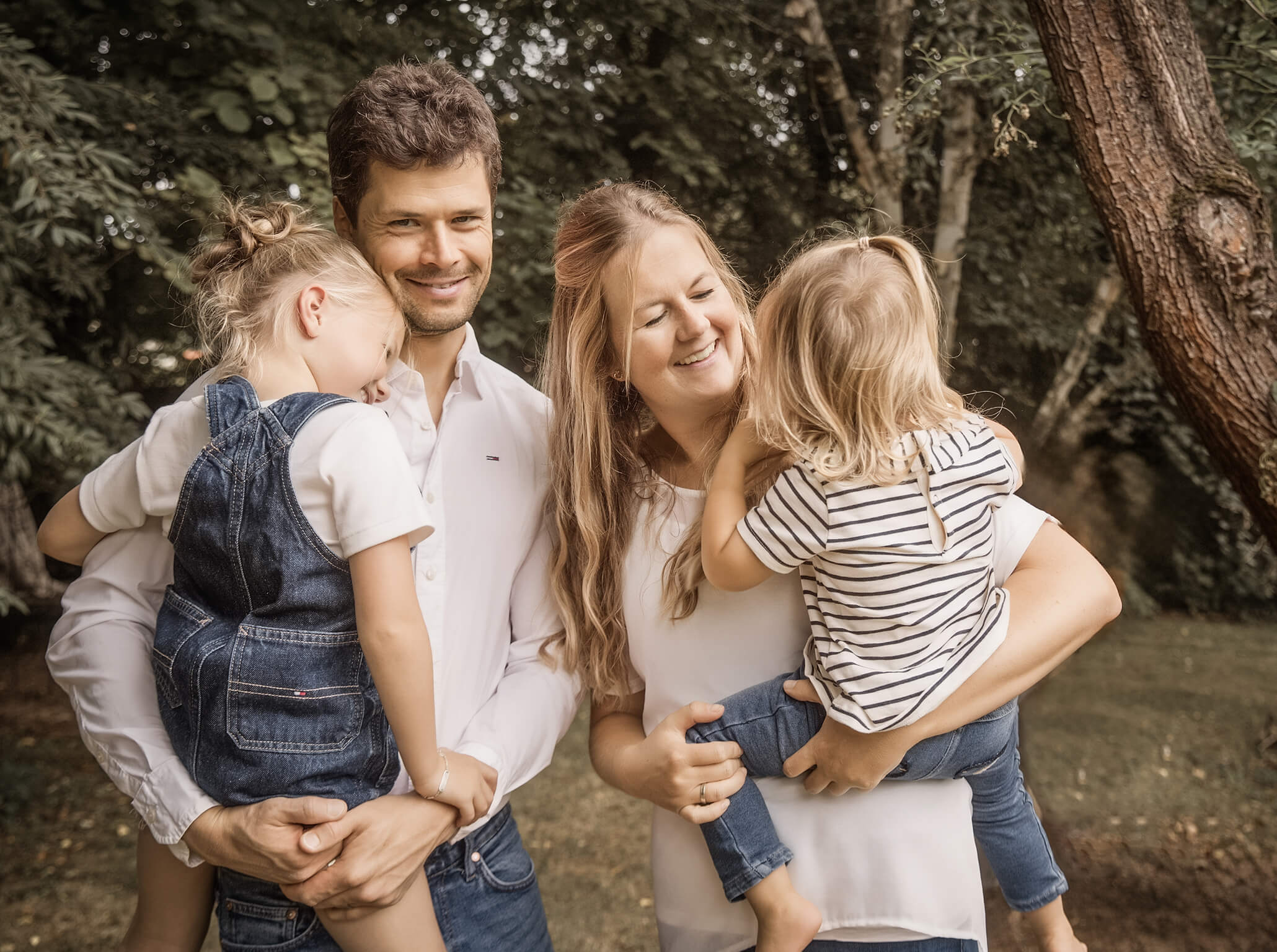 Familienfoto-Gartenatelier-Fotostudio-Lichtblick-Pegnitz Familie mit zwei Kindern im Gartenatelier, Eltern halten die Kinder im Arm, natürliche Szene.