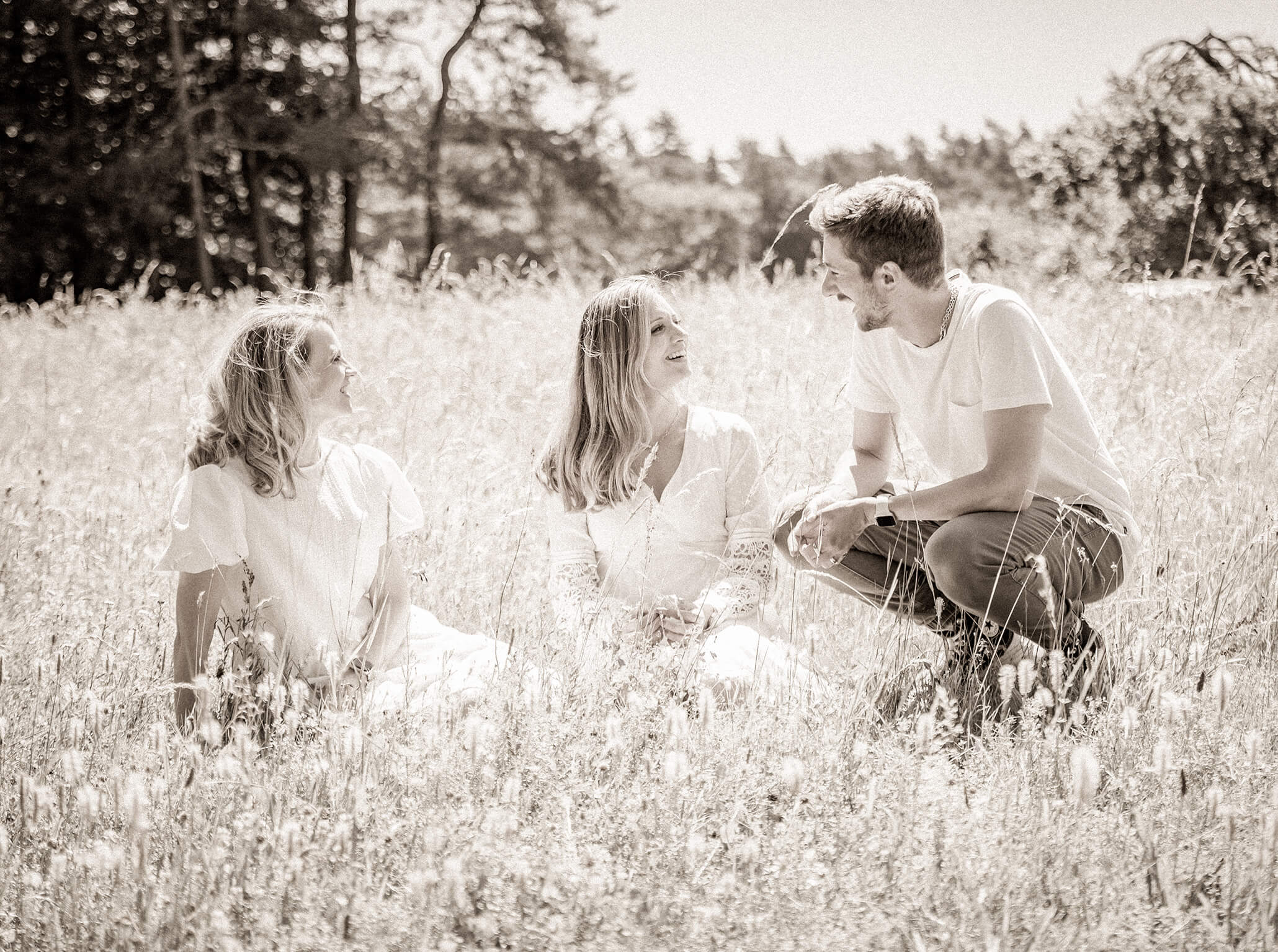 Familyportrait-pegnitz-geschwisterbilder-fotostudio-lichtblick Drei erwachsene Geschwister in einer Wiese, helles Gegenlicht und natürlicher Look.