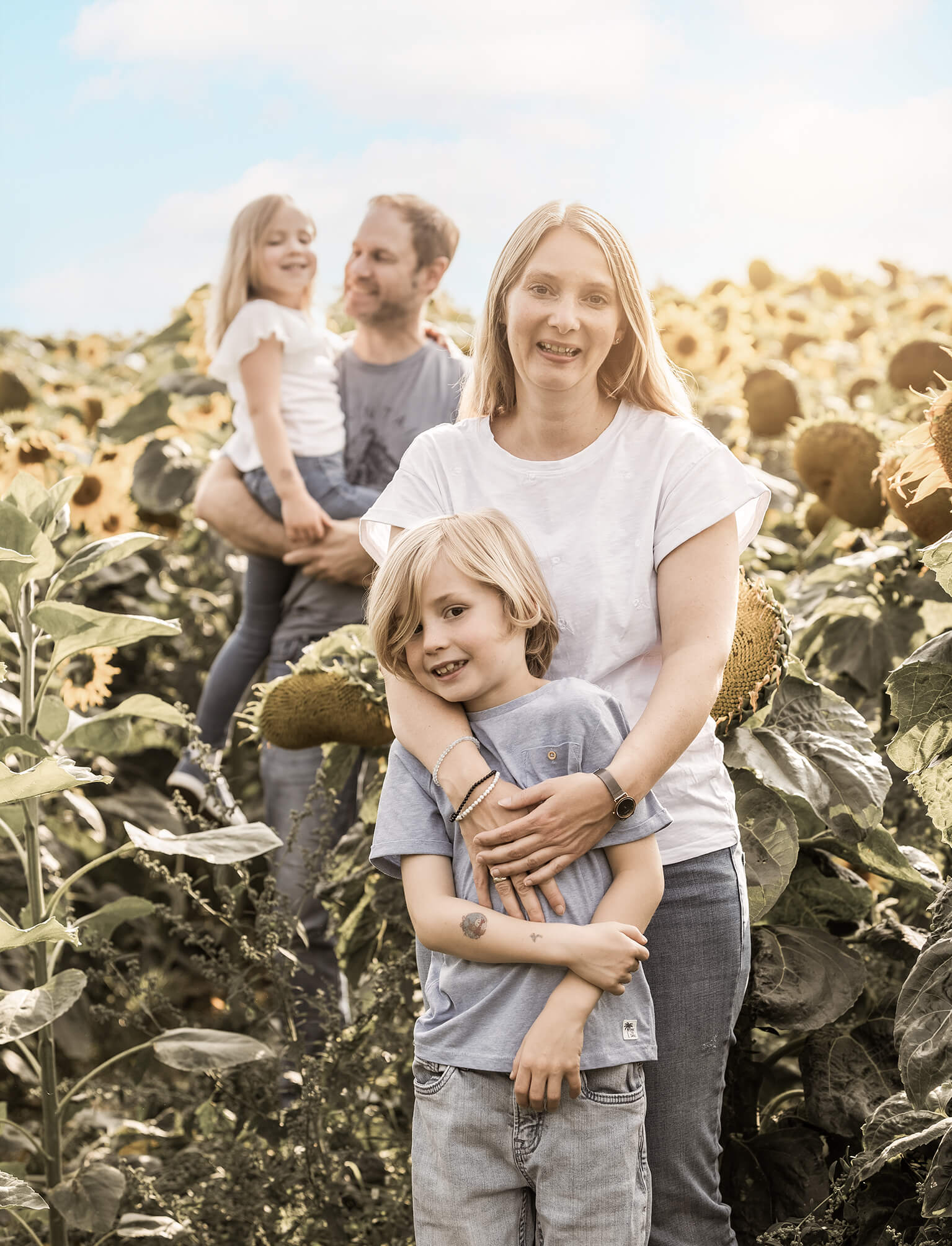 Sonnenblumenfeld-fränkischeschweiz-doris-dörfler-familieylove Familie im Sonnenblumenfeld, Eltern und zwei Kinder in natürlicher Szene.