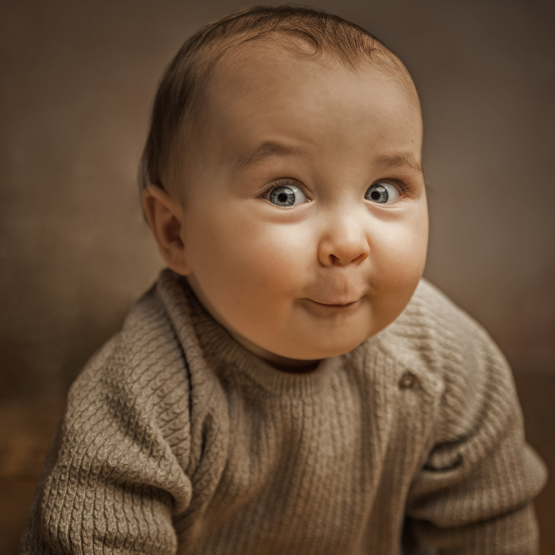 Krabbelndes Baby vor Tulpen, freches Kinderfoto mit direktem Blick in die Kamera.
