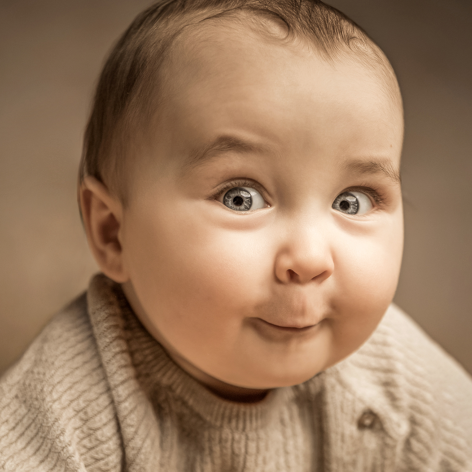 Krabbelndes Baby vor Tulpen, freches Kinderfoto mit direktem Blick in die Kamera.