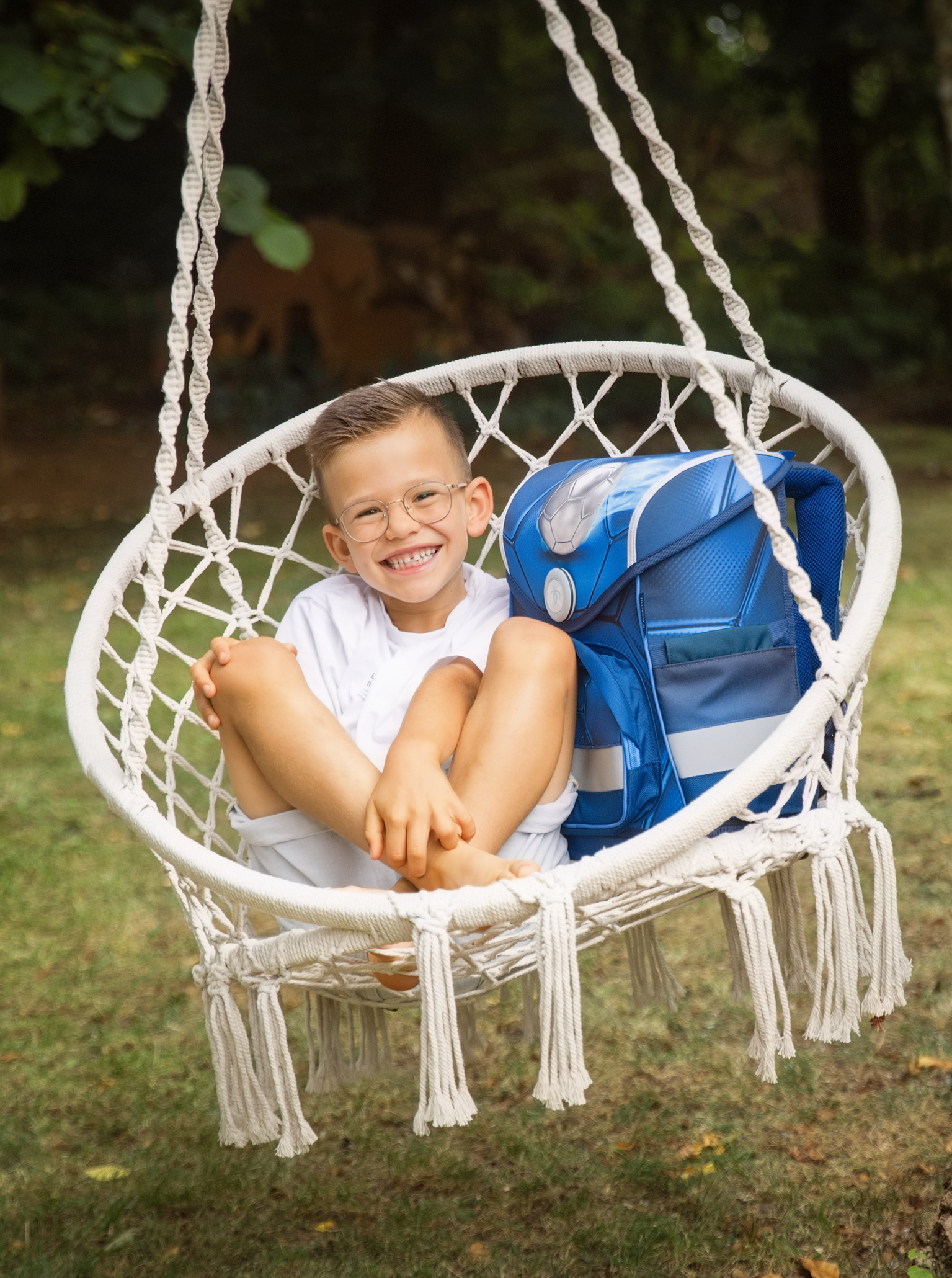 Schulanfangfotos-fussballjunge-Doris-Dörfler-2026-Fotostudio-Lichtblick-Pegnitz-family Junge sitzt in einem Hängesessel im Garten
