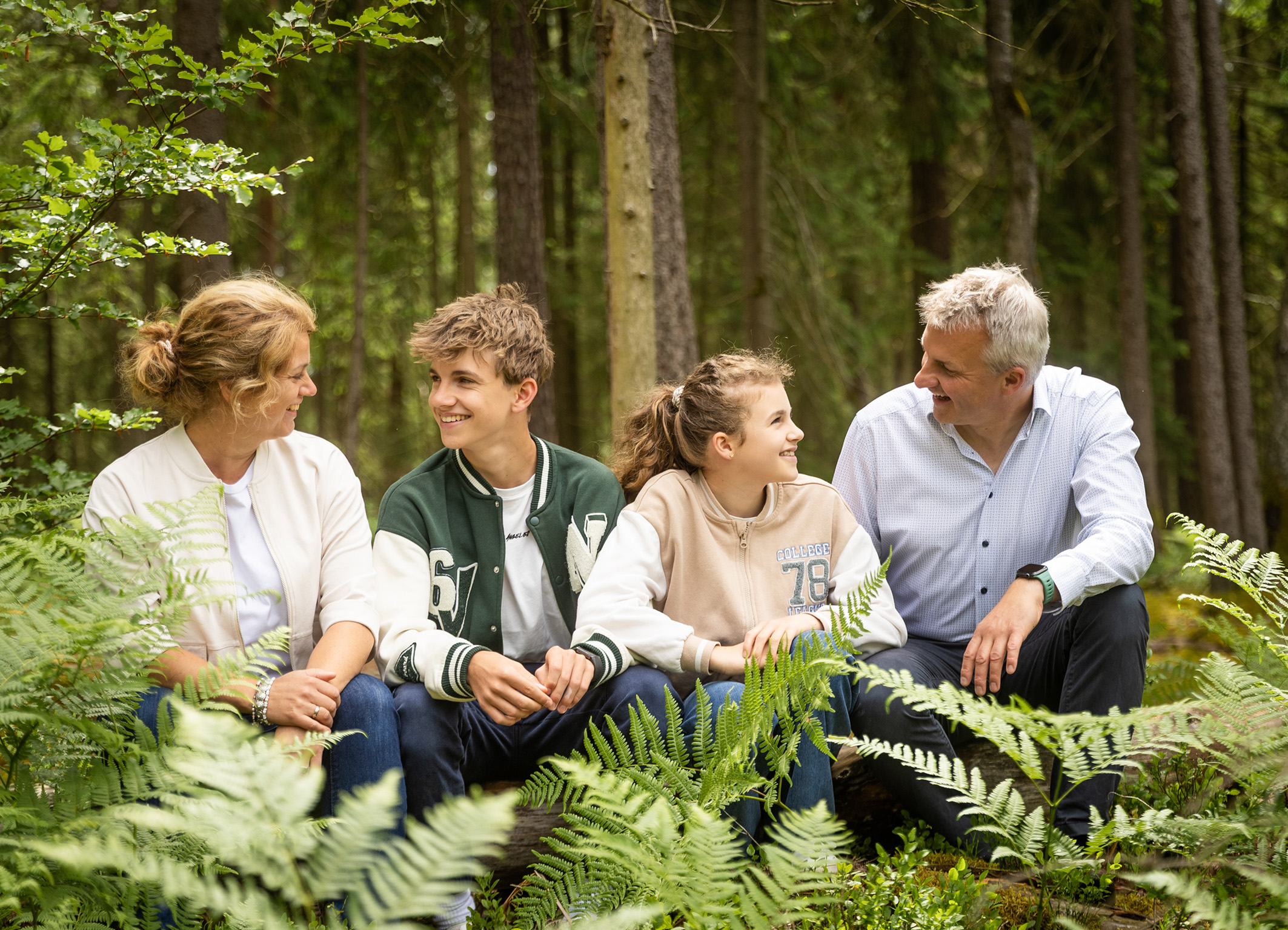 familyportrait-foto-indernatur-veldensteinerforst-doris-dörfler-pegnitz lockeres Familienfoto im Wald, Familie sitzt auf einem umgestürtzen Baumstamm